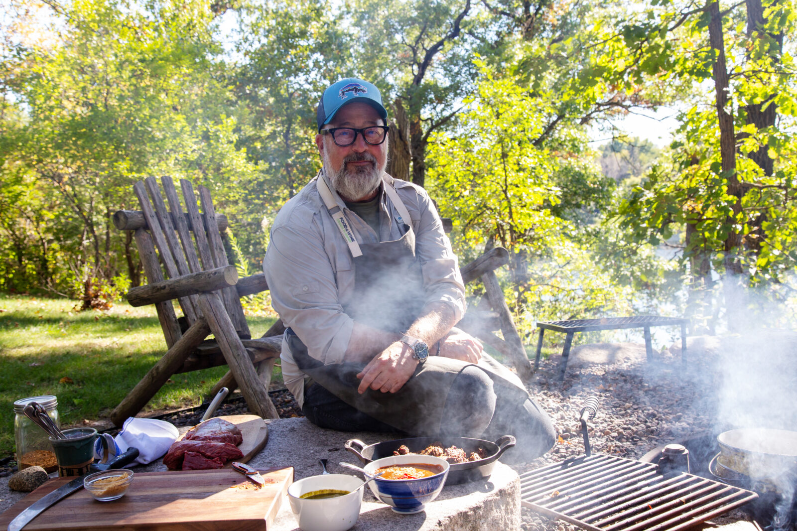 Andrew Zimmern cooking by the fire